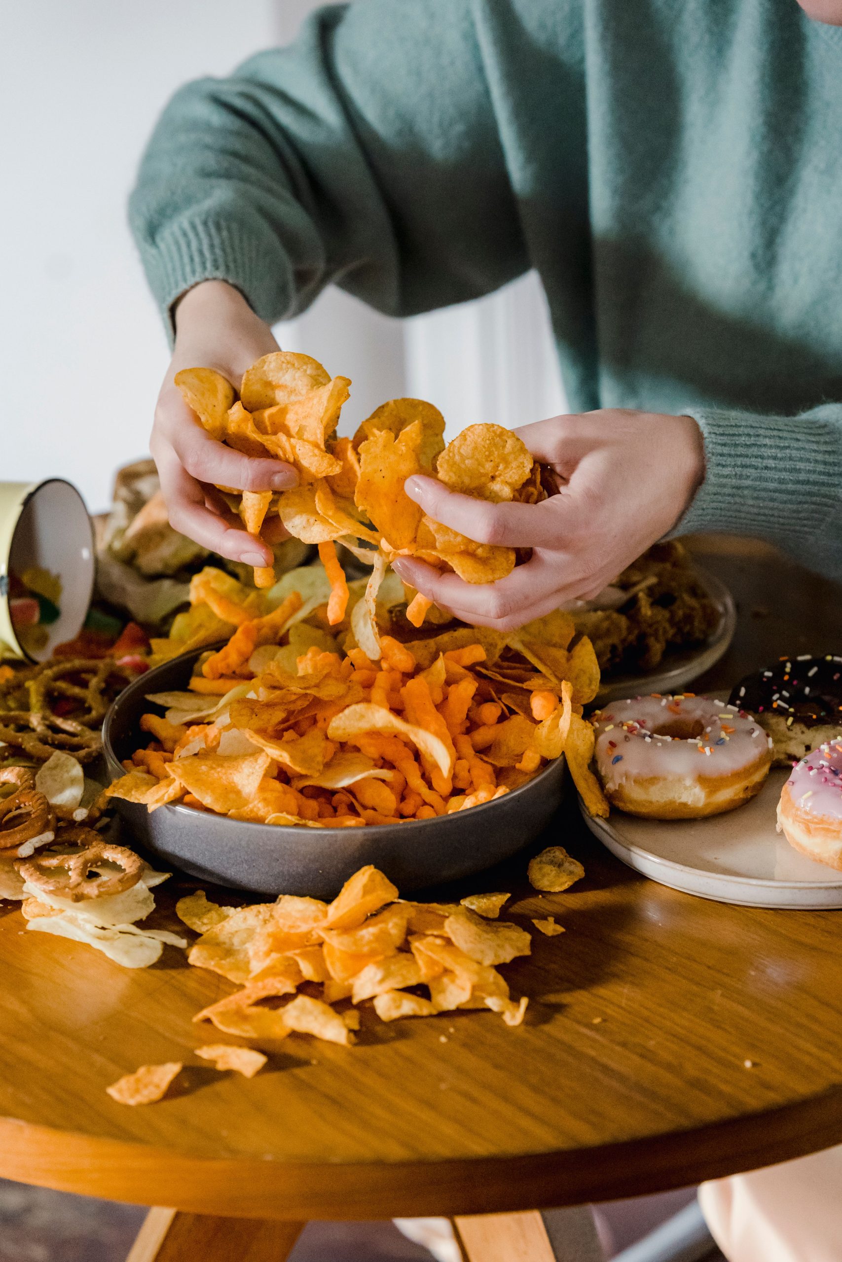 Fame nervosa da stress: mani che afferrano cibo spazzatura, effetto del cortisolo alto